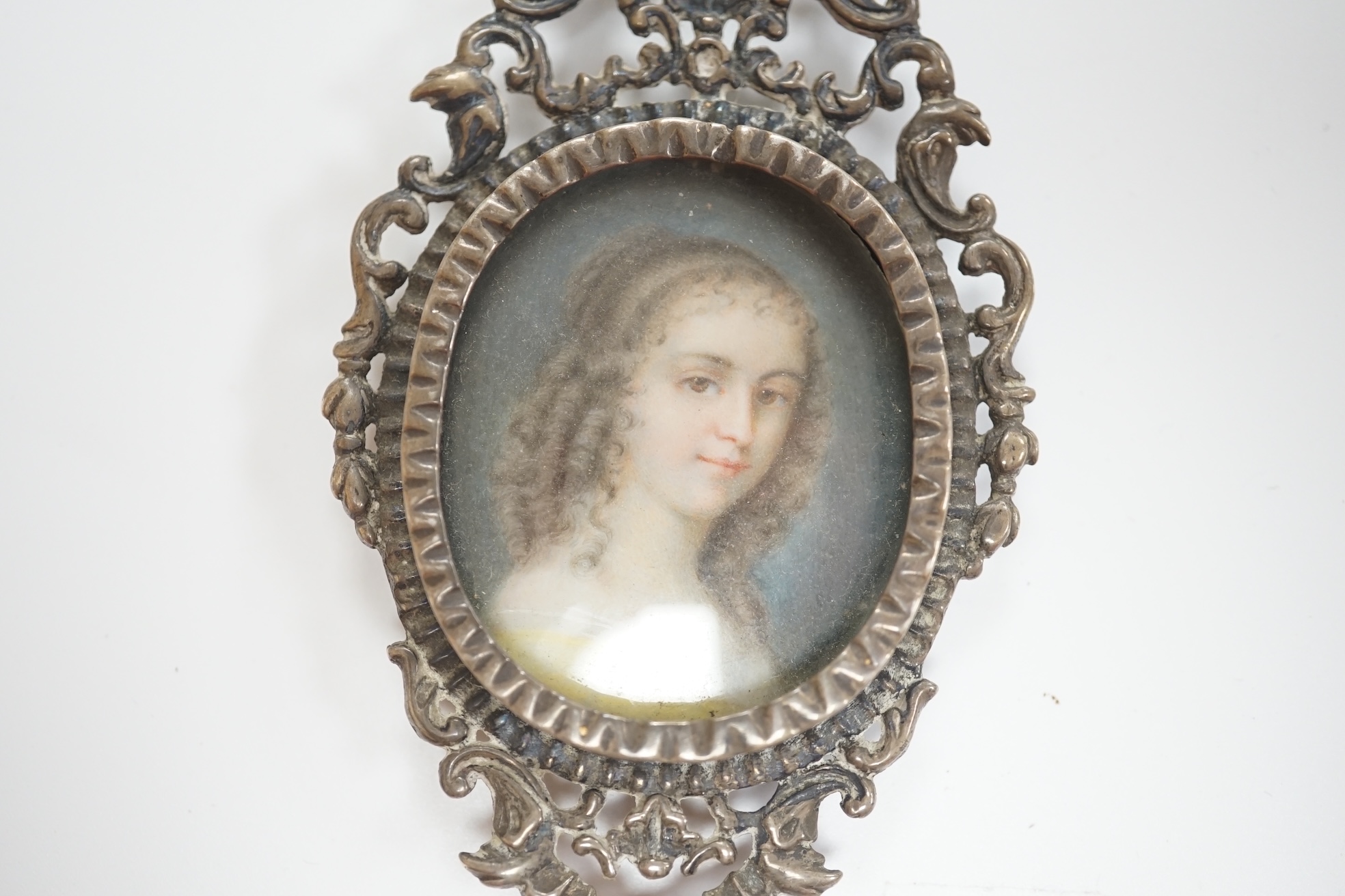 English School circa 1840, watercolour on ivory miniature portrait of a young lady with ringlets, size overall 10cm high, housed in an ornate silver frame. CITES Submission reference 8JBKVYPE. Condition - fair to good